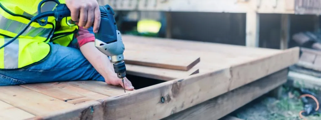 construction worker installing wood deck